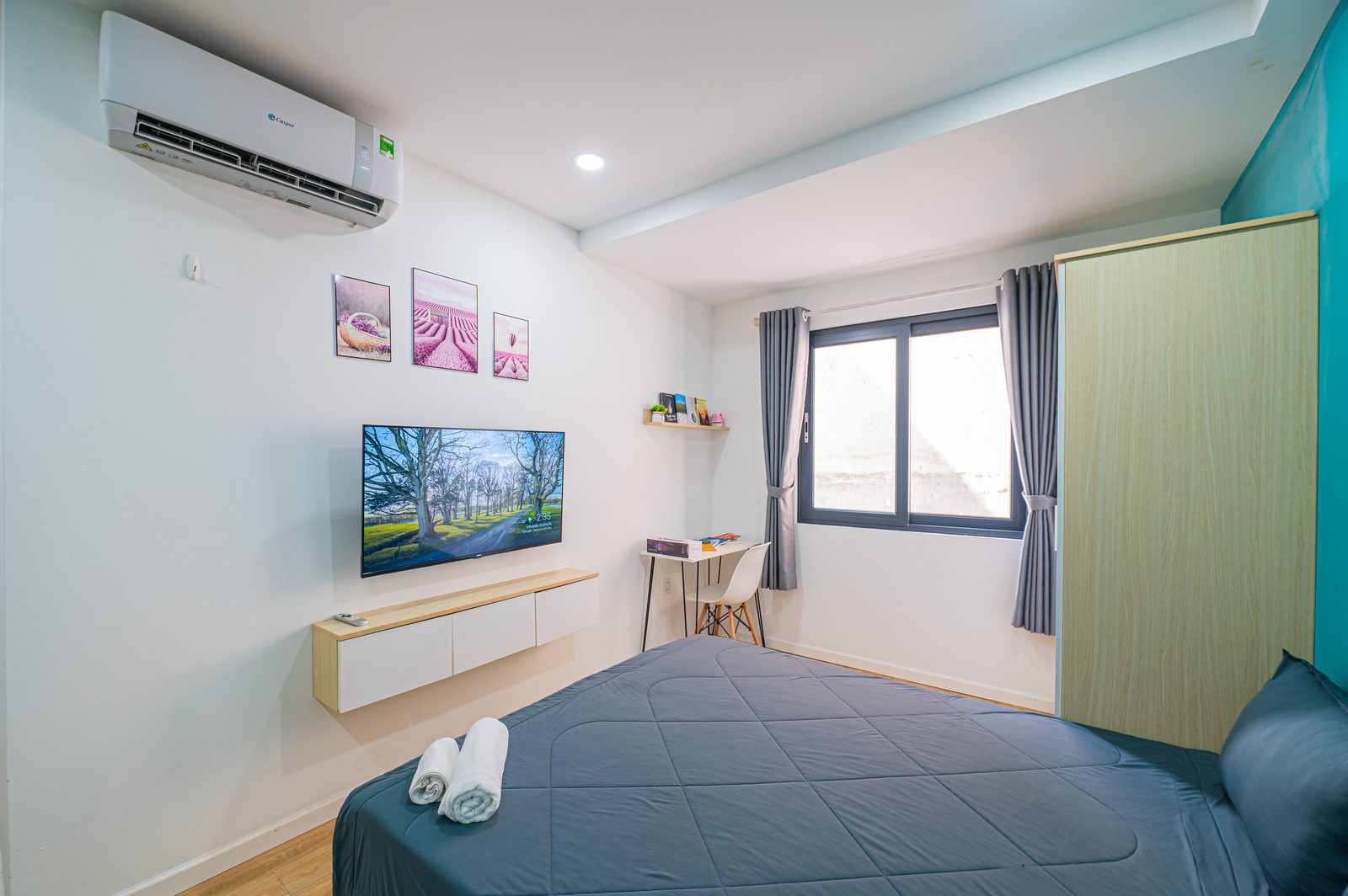 Studio 2.4 interior with queen bed, kitchenette and large windows