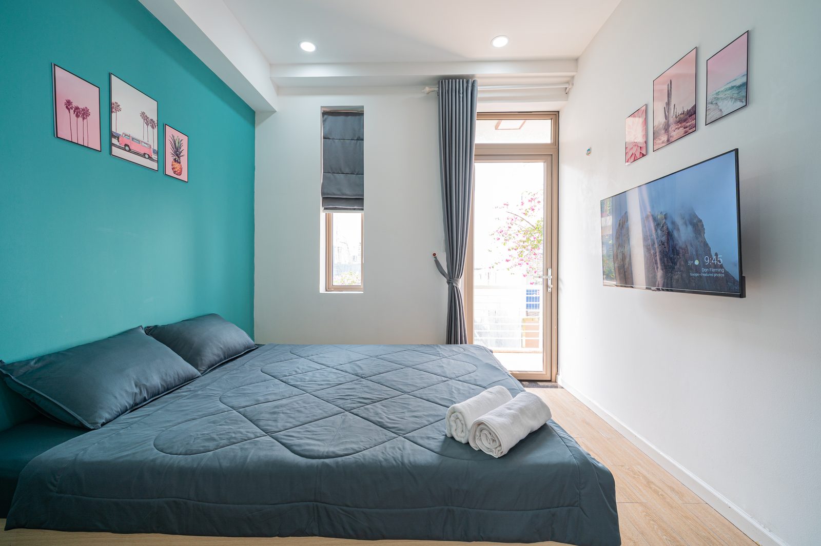 Studio 3.1 interior with queen bed, teal accent wall and private balcony