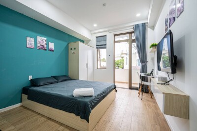 Studio 5.2 interior with queen bed and balcony door